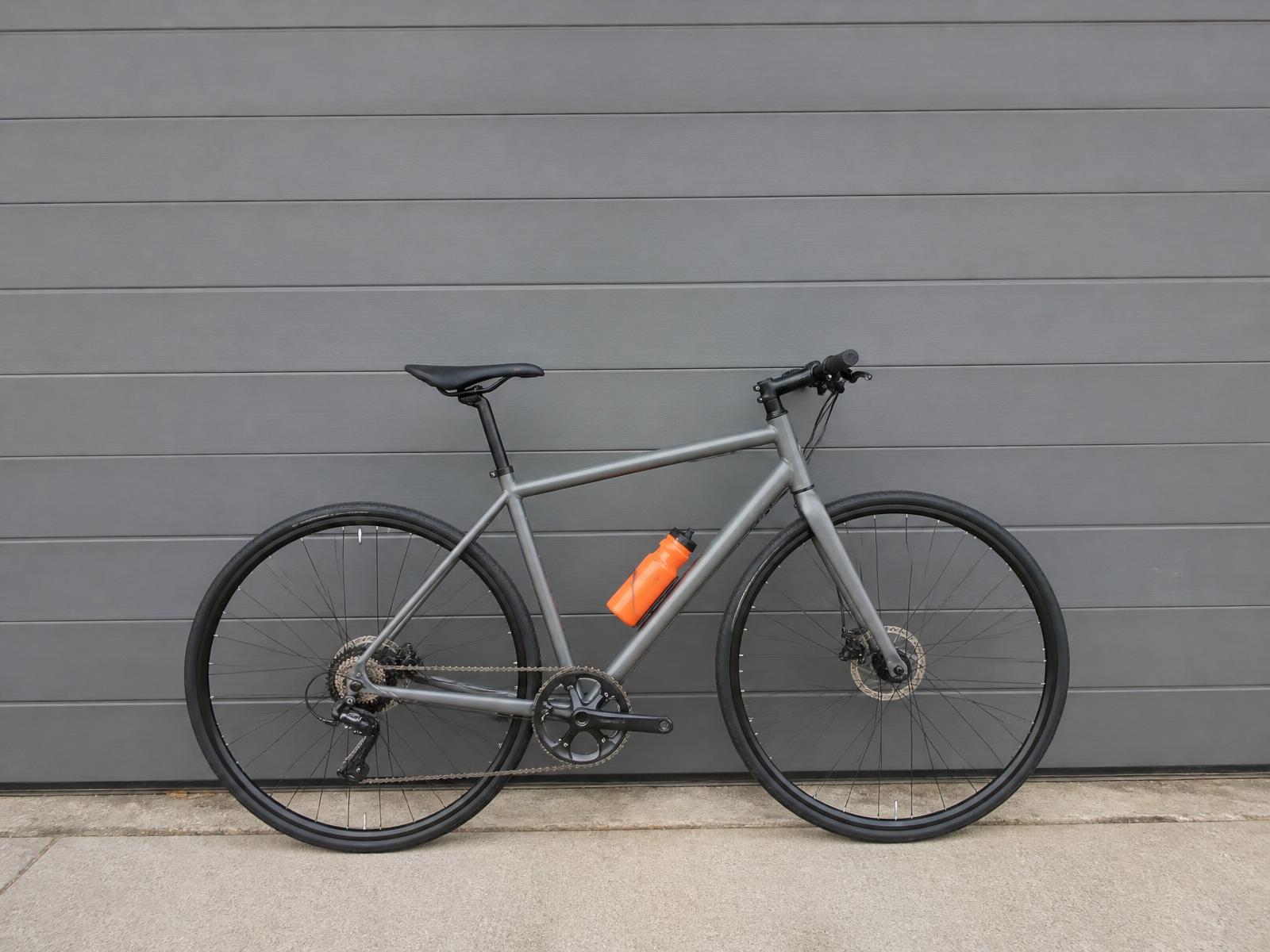 Bicycle leaning against a garage door — John cycles out to collect customers' vehicles in Thornbury